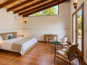 a bedroom with a bed and a table and chairs at Finca Tramuntana in Palma de Mallorca