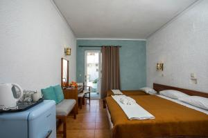 a hotel room with two beds and a desk at CASA MIKELE by Sarikas - SEA SIDE SUITES and STUDIOS -adults only in Faliraki