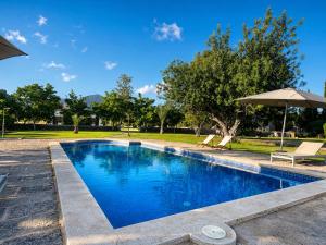 a swimming pool with chairs and an umbrella at Finca Tramuntana in Palma de Mallorca