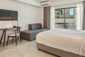 a bedroom with a bed and a desk and a chair at Scala Boutique Hotel & Suites - Adults Only in Agia Pelagia +37 photos