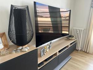 a large entertainment center with a large flat screen tv at Séjour agréable à Plaisir - 456 in Rouen