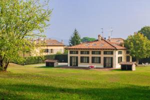 a large house in a yard with a grass field at Borgo Malvasia- La Quercia in Sasso Marconi