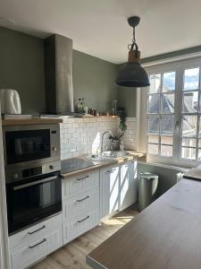 a kitchen with a sink and a microwave at Séjour agréable à Plaisir - 456 in Rouen +16 photos