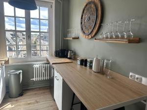 a kitchen with a counter and a large clock on the wall at Séjour agréable à Plaisir - 456 in Rouen