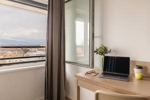 a laptop on a desk in a room with a window at Appart'City Confort Mulhouse in Mulhouse +33 photos