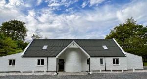 a white barn with a black roof at Big Lodge in Peebles