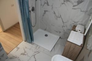 a bathroom with a shower and a white marble wall at CR BnB Rozzano 2 in Rozzano +11 photos