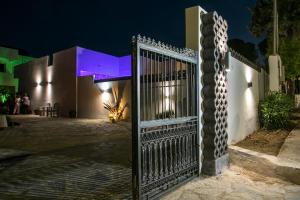 a gate in front of a house at night at CASA MIKELE by Sarikas - SEA SIDE SUITES and STUDIOS -adults only in Faliraki