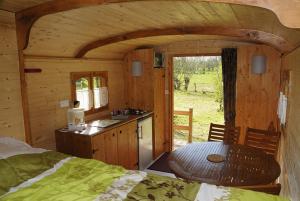 a room with a kitchen and a table in a cabin at La Ferme du Marais Poitevin - Chambre d'hôtes in Benet