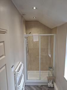 a shower with a glass door in a bathroom at The Reading Rooms in Haydon Bridge