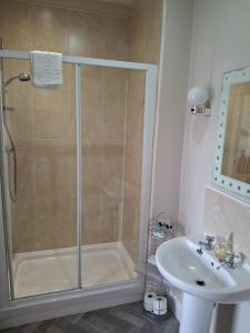 a bathroom with a shower and a sink at The Reading Rooms in Haydon Bridge +8 photos