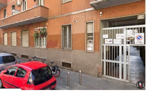 a red car parked in a parking lot next to a building at Zippy Hostel in Milan