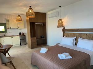 a bedroom with a bed with two towels on it at Remezzo Kimolos in Kimolos