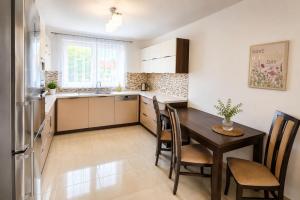 a kitchen with a table and chairs and a refrigerator at Apartmán Hollého in Žilina