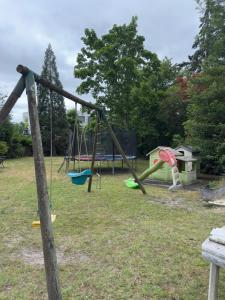 a swing set in a park with a playground at Aux Châtaigniers in Langon