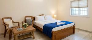 a bedroom with a bed and a table and a chair at Sri lucky grand lodge and function hall in Raigīr