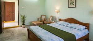 a bedroom with a bed and a table and chairs at Sri lucky grand lodge and function hall in Raigīr +4 photos