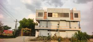 a white building with a lot of windows at Sri lucky grand lodge and function hall in Raigīr