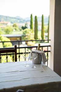 a table with two wine glasses on a balcony at Agriturismo La Dolza in Follina