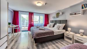 a bedroom with a large bed with red curtains at Maja Pokoje z Widokiem in Mirsk