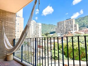 a hammock on a balcony with a view of a city at Distrito Prime 1-302 in Bogotá