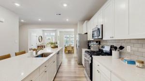 a white kitchen with a sink and a stove at Milos Haven house with community pool in Frankford +16 photos