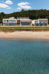 a house on the beach next to the water at Aeolia Residences in Nea Potidaea