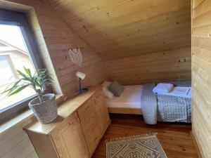 a room with a bed in a wooden cabin at Kameleon2 in Dźwirzyno