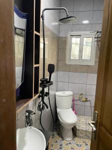 a bathroom with a white toilet and a sink at Mak house in Douala