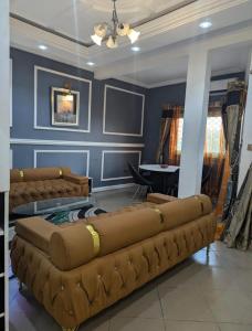 a living room with two large brown leather couches at Mak house in Douala