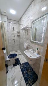 a bathroom with a sink and a toilet and a mirror at AL MIDYAF Appart'Hôtel in El Jadida +64 photos