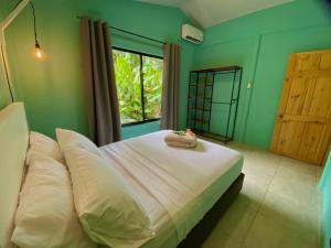 a bedroom with a large white bed with a window at Lugar Mágico in Puerto Viejo