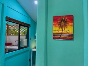 a bathroom with a painting of a palm tree on the wall at Lugar Mágico in Puerto Viejo +33 photos