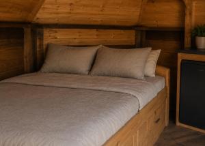 ein großes Bett in einer Holzhütte mit in der Unterkunft Tinyhouse De Einder in Pieterburen