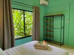 a bedroom with a bed with a window and a book shelf at Lugar Mágico in Puerto Viejo