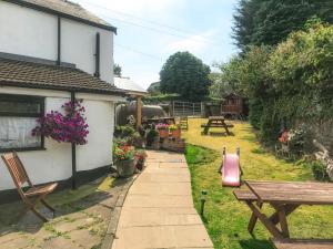 a garden with a bench and a picnic table at Brewery Lodge Sleeps 4 in Lydney