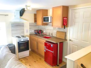 a small kitchen with a red refrigerator and a stove at Brewery Lodge Sleeps 4 in Lydney +2 photos