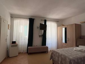 a bedroom with a bed and a television and curtains at Old Town Mattarelli Studio in Kotor