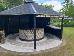 a black gazebo with a hot tub in the grass at Holiday Home Calli by Interhome in Give +16 photos