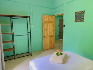 a room with blue walls and a bed with a towel at Lugar Mágico in Puerto Viejo