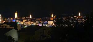 a city lit up at night with a clock tower at Oaza Puljar-Matić in Banjol