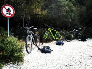 two bikes parked on the beach next to a sign at Oaza Puljar-Matić in Banjol