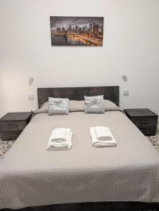 a large bed with two towels on top of it at Koras 142 in Sennori