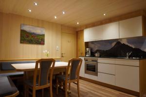 a kitchen with a table and chairs in a room at Pension Edelweiss in Damuls +35 photos