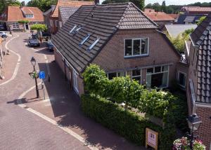 a house with a tile roof on a street at Het Bakkershuus in Gramsbergen