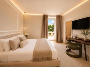 a hotel room with a bed and a desk and a television at Greif Hotel & Spa in Trieste +175 photos