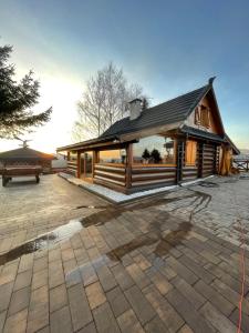 a wooden building with a bench in front of it at Nasza Chata in Jaworzynka +7 photos