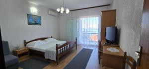 a bedroom with a bed and a tv and a window at Karmen 2 in Sveti Juraj