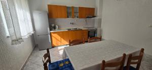 a kitchen with a table with chairs and a refrigerator at Karmen 2 in Sveti Juraj +7 photos