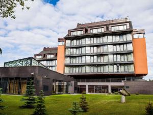 a large building with a grass field in front of it at Mercure Palanga Vanagupe Resort & SPA in Palanga
